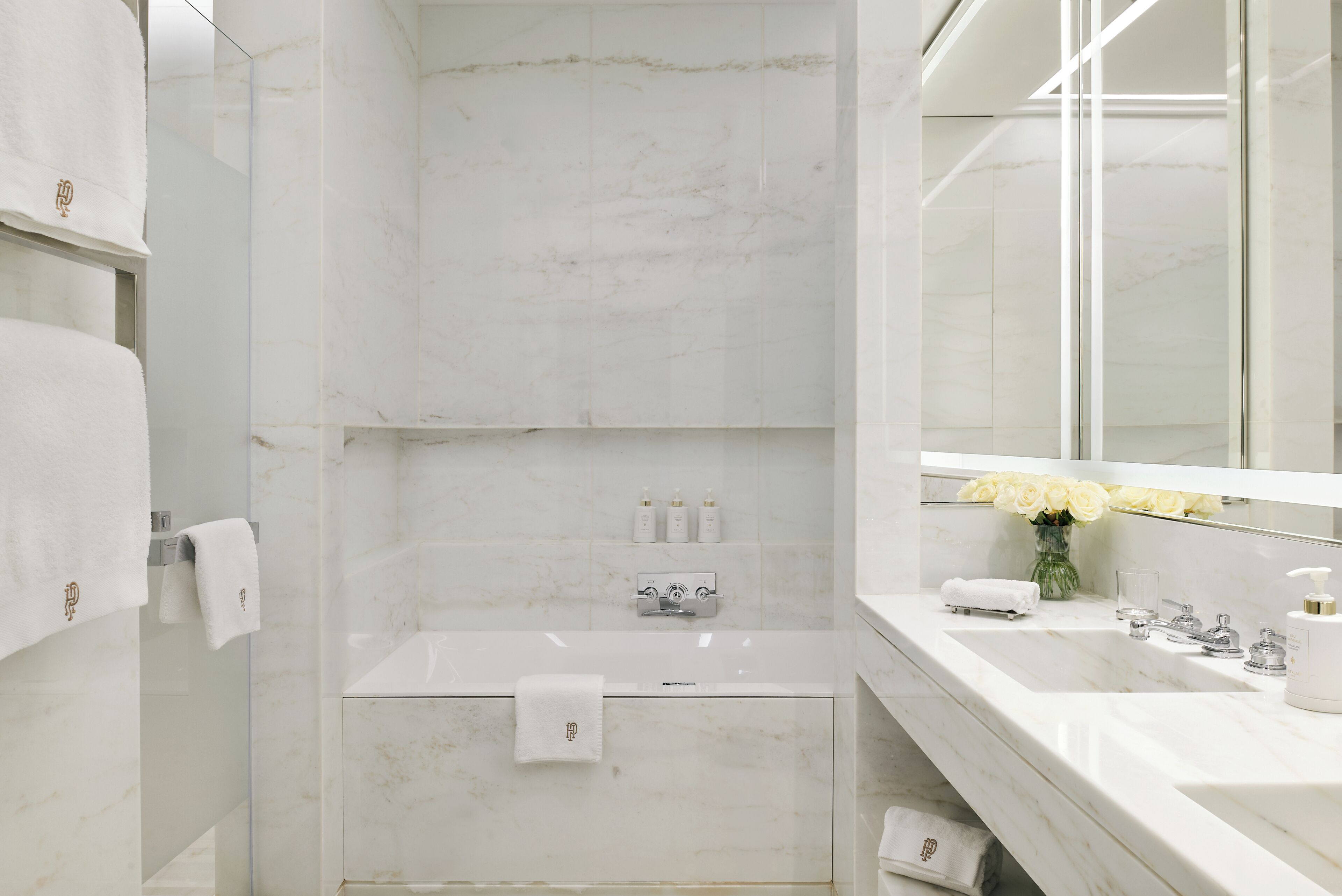Une salle de bain moderne avec une baignoire, un lavabo et un miroir.