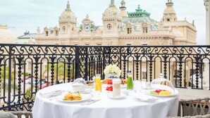 A table set for breakfast with a view of a grand building with domes and spires. - Hôtel de Paris Monte-Carlo (Monaco)
