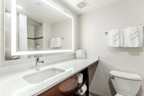 A modern bathroom with a large mirror, a white sink, a toilet, and a towel rack. - Holiday Inn Express Philadelphia - Penns Landing by IHG (Philadelphia)