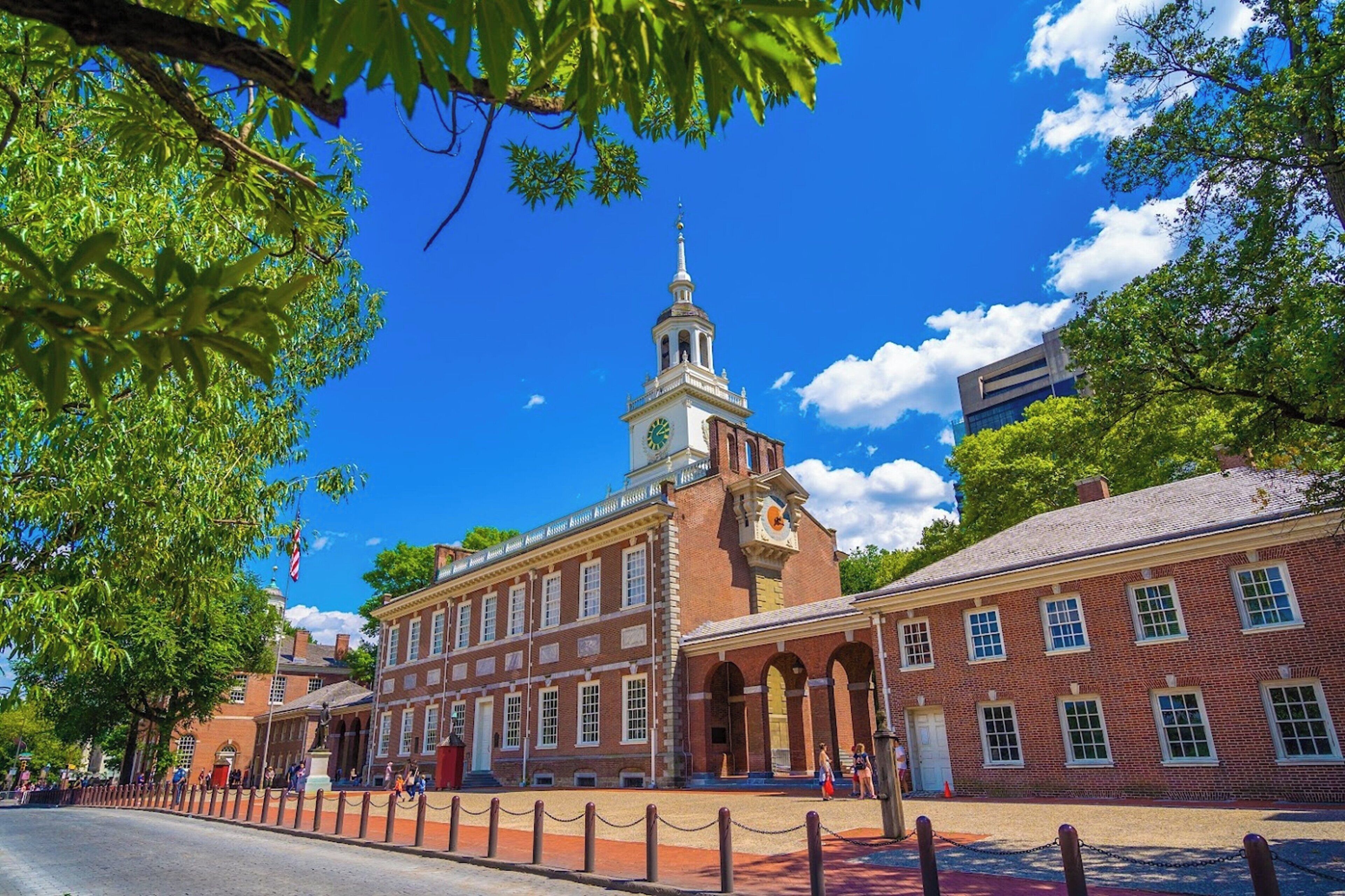 A historic building with a clock tower, brick architecture, and arched walkways.