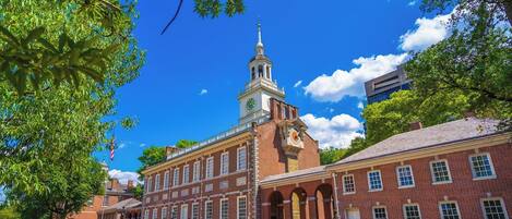 A historic building with a clock tower, brick architecture, and arched walkways.