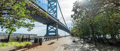 A pedestrian bridge with a view of a large blue bridge in the background.