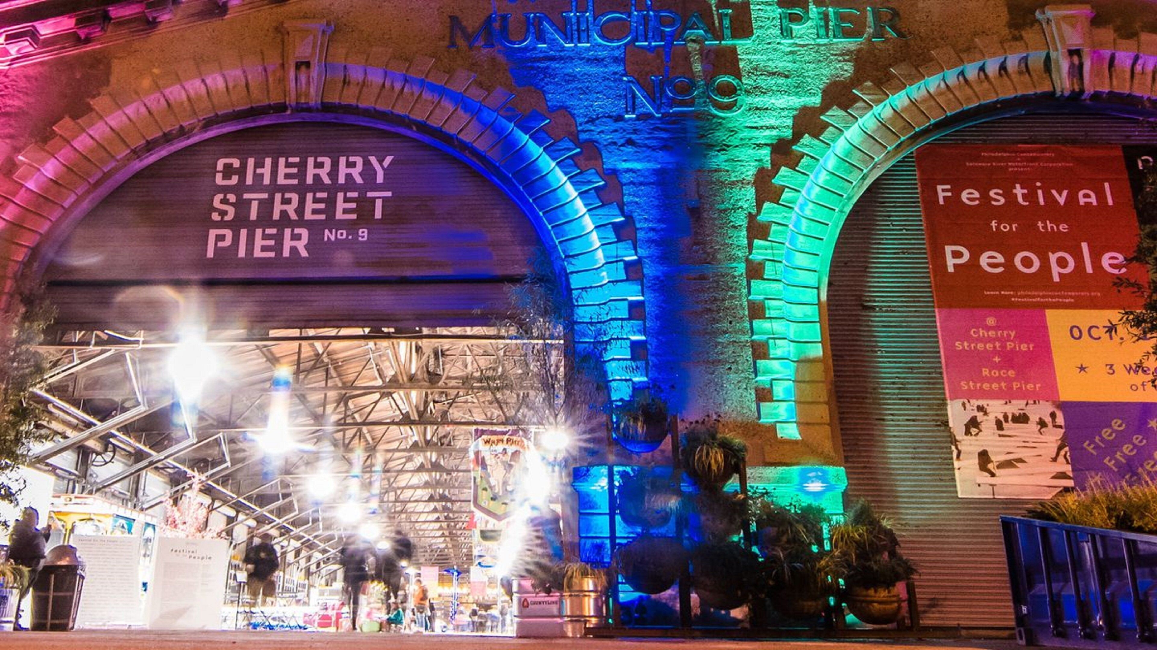 The exterior of the Municipal Pier No. 9 with illuminated arches and a sign for the Cherry Street Pier.