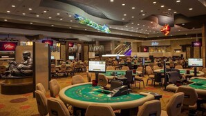 A casino with multiple blackjack tables, a large statue, and a prominent casino sign. - Rodeway Inn Artesia Cerritos (Artesia)