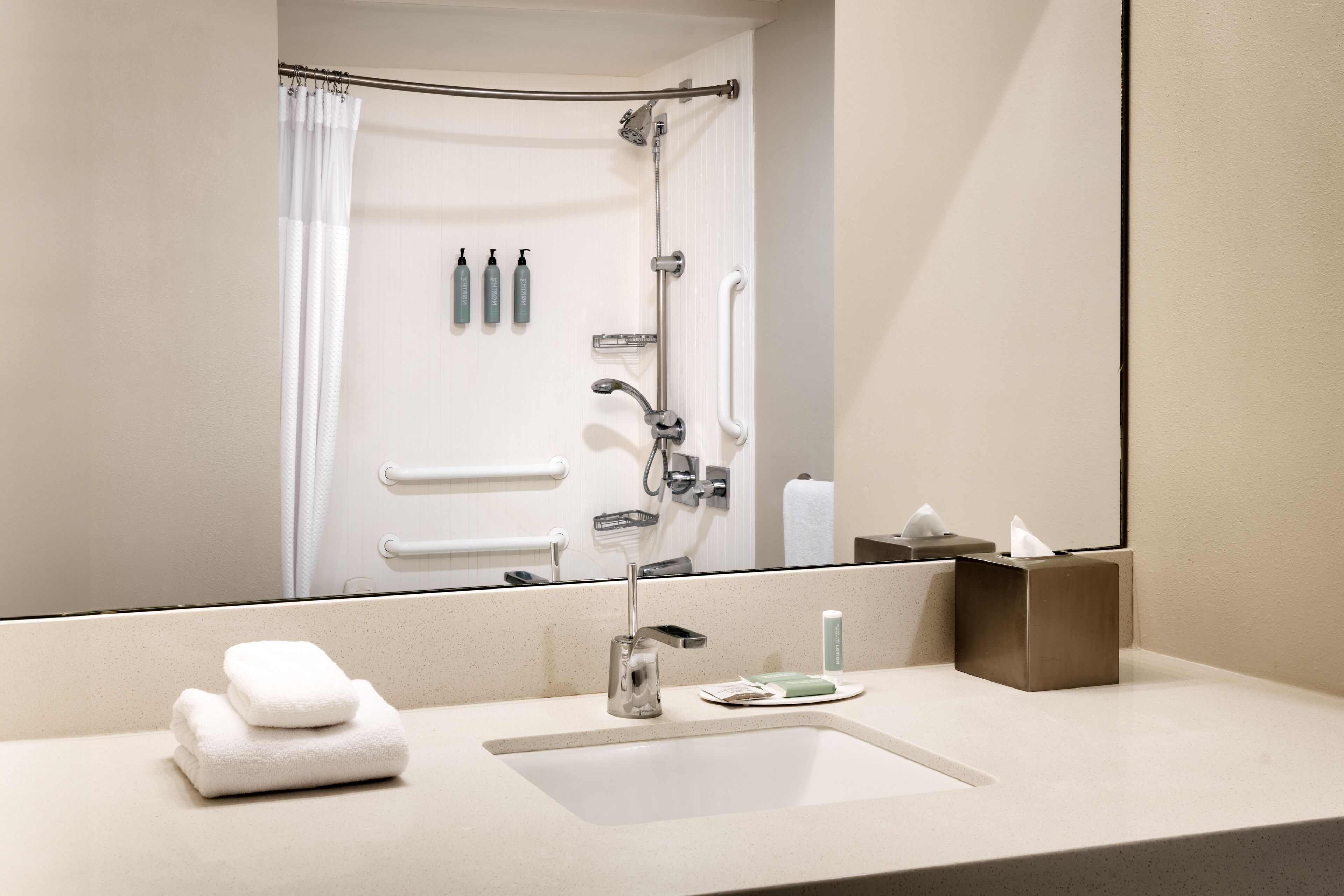 Un baño con lavamanos, espejo y artículos de aseo.