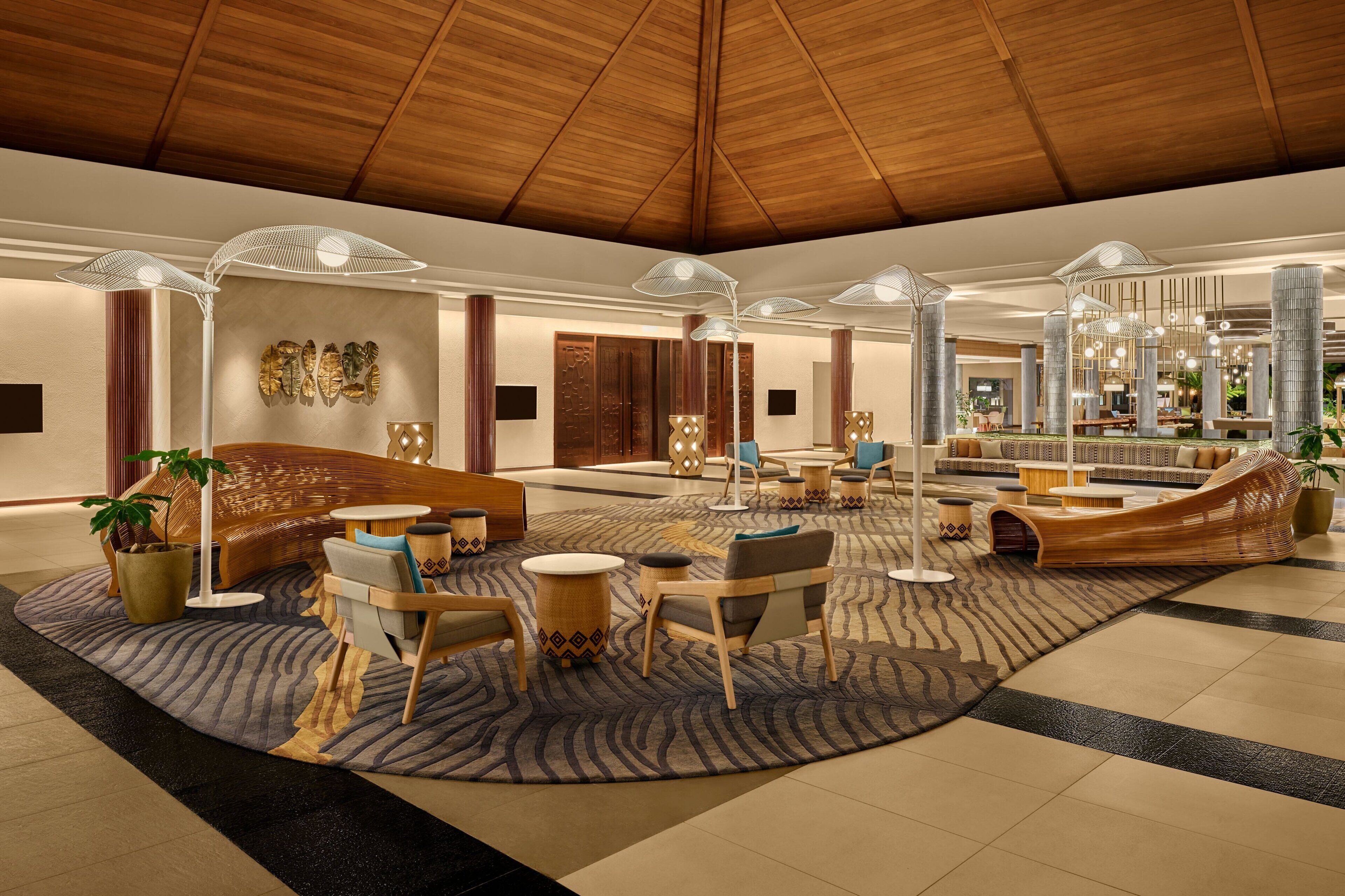 Un hall d’entrée spacieux avec un plafond haut, un mobilier moderne et un éclairage décoratif.