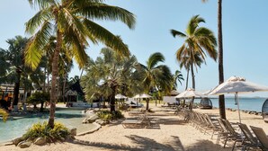 A beachside resort with a pool, palm trees, and lounge chairs. - Sheraton Fiji Golf & Beach Resort (Nadi)
