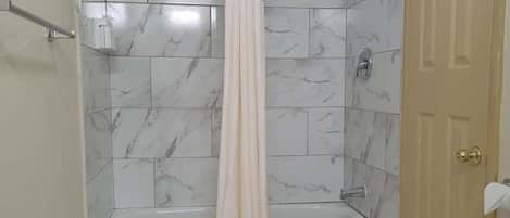 A bathroom with a bathtub, a shower, and a toilet.