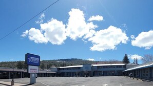 A motel with a signboard advertising free breakfast and a parking lot. - Americas Best Value Inn Williams Grand Canyon (Williams)