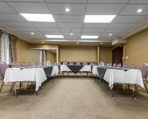 Una sala de conferencias con una larga mesa, sillas y alfombra.