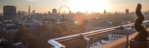 A cityscape with a prominent Ferris wheel, modern buildings, and a mix of architectural styles. - The Cavendish London (London)