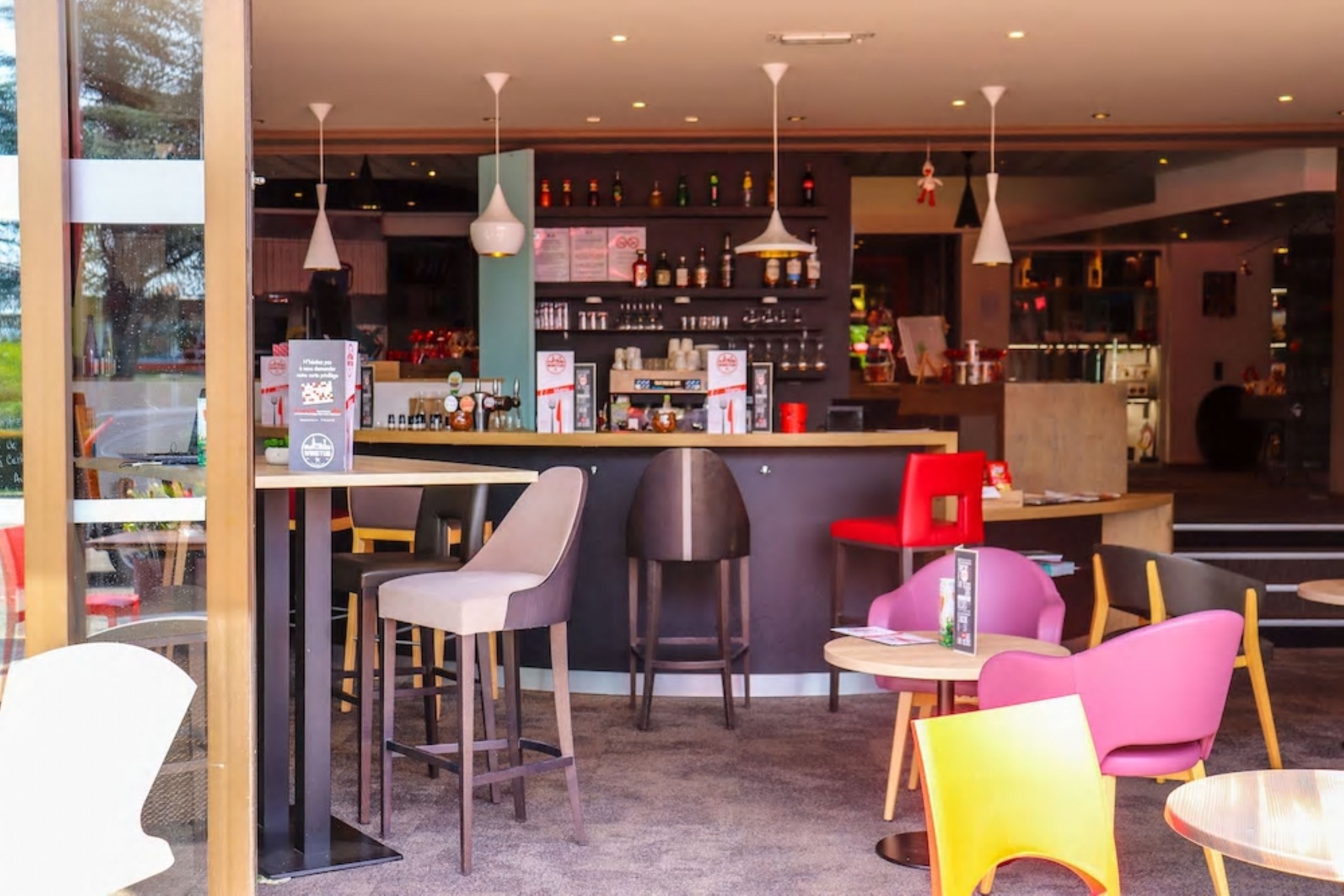 Een moderne bar met een aanrecht, barkrukken en hangende吊り下げ式ランプ.