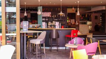 Een moderne bar met een aanrecht, barkrukken en hangende吊り下げ式ランプ.