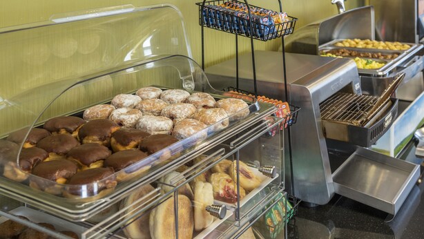 Un buffet proposant une variété de produits de boulangerie, notamment des pâtisseries et des muffins.
