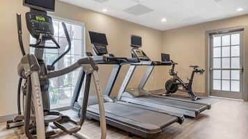 Una palestra con tapis roulant, ellittiche e una cyclette.
