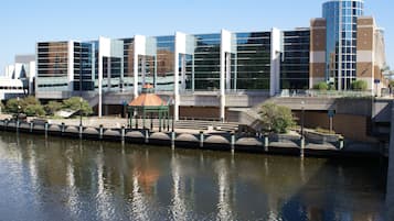 Un bâtiment moderne aux fenêtres en verre réfléchissant, avec un pont et un canal.