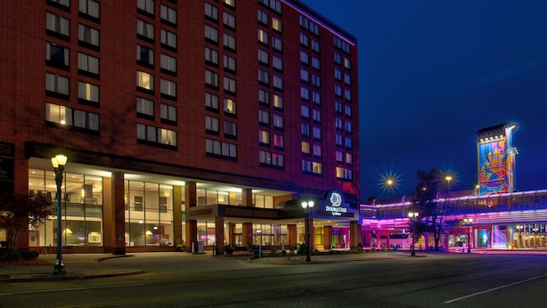 A hotel with a brick facade, large windows, and a brightly lit entrance. - DoubleTree by Hilton Lansing (Lansing)