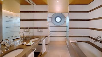 Ein modernes Badezimmer mit zwei Waschbecken, einem großen Spiegel und einem runden Dachfenster.