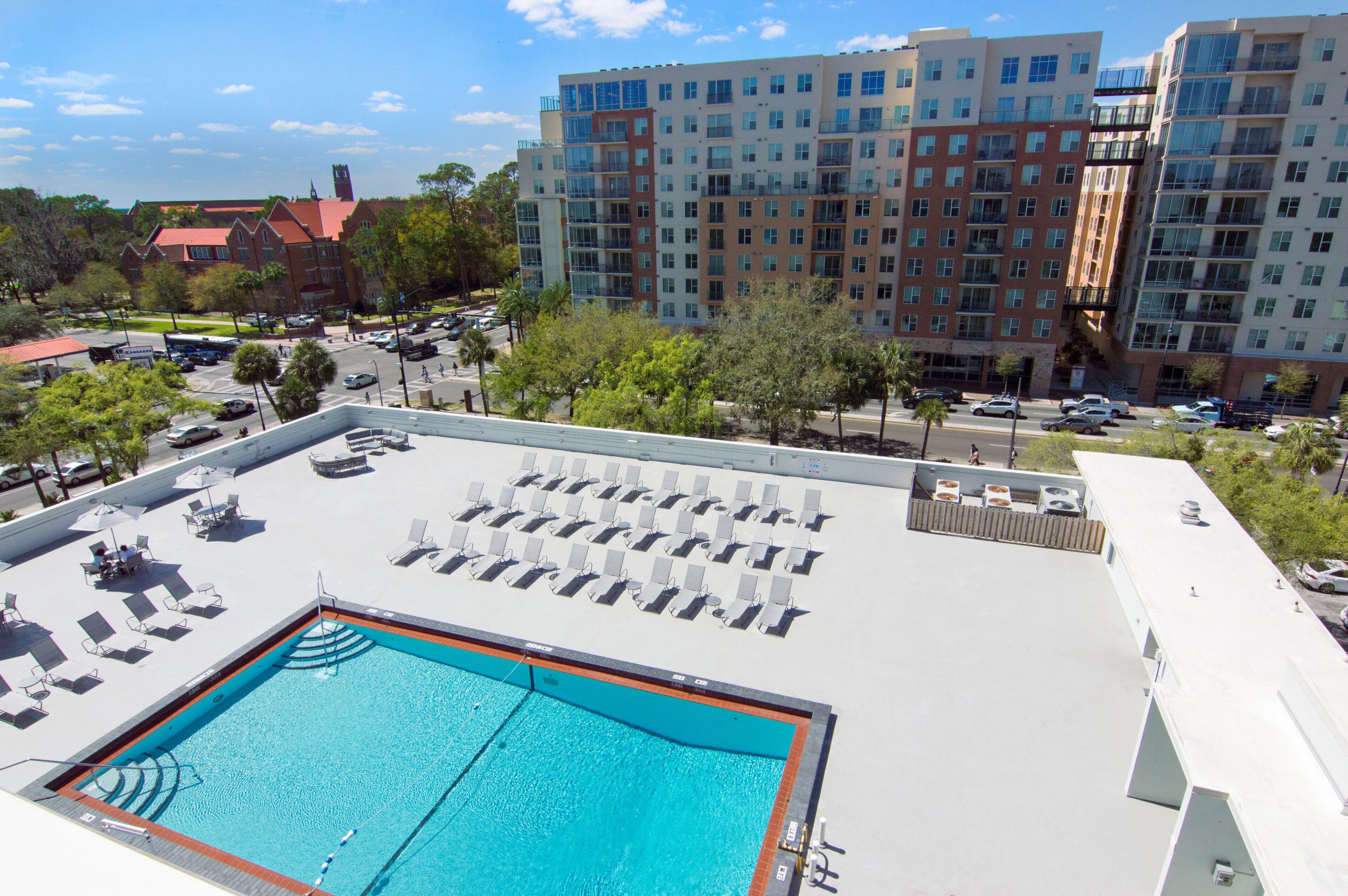 A rooftop pool area with sun loungers and a swimming pool.