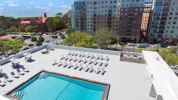 A rooftop pool area with sun loungers and a swimming pool.