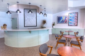 Une cuisine moderne dotée d’un îlot central aux lignes courbes, d’un éclairage suspendu et d’une carte de Gainesville accrochée au mur.