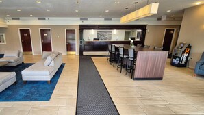 A hotel lobby with a reception desk, seating area, and a bar. - Quality Inn & Suites (Sydney)