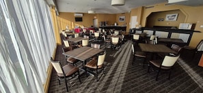 A restaurant with multiple tables and chairs, a bar area, and a television screen on the wall. - Quality Inn & Suites (Sydney)