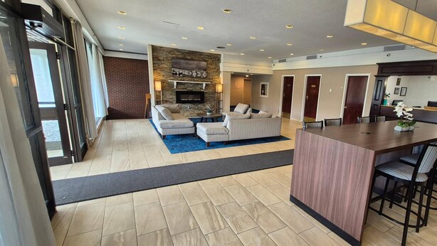 A modern living room with a fireplace, sofas, a coffee table, and a bar area. - Quality Inn & Suites (Sydney)