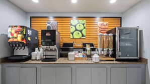 Un espace dédié au café, équipé de plusieurs machines à café, d’une vitrine réfrigérée et d’un comptoir où sont exposés divers produits.