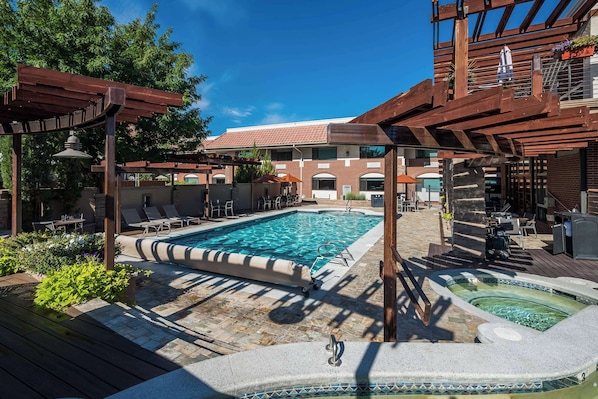 Una piscina al aire libre de temporada, sombrillas