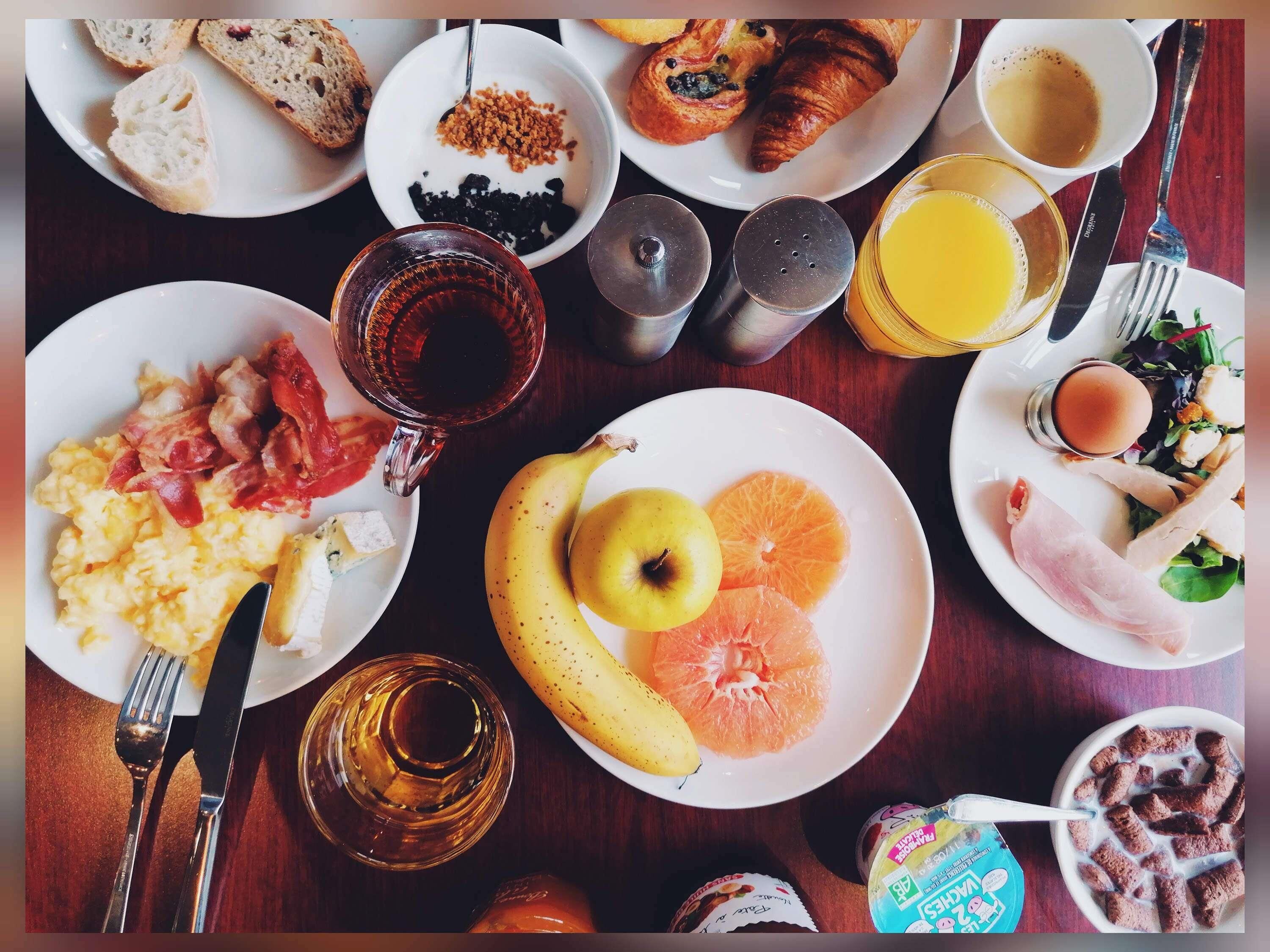 A breakfast spread with various food items and drinks on a table.