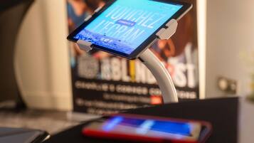 A tablet on a stand with a smartphone on a table, both displaying screens.
