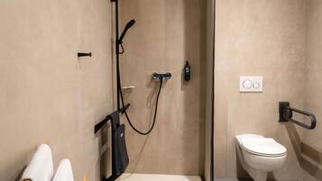 Une salle de bain moderne équipée d’une douche, de toilettes et d’un porte-serviettes.