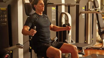 Un hombre usando una máquina de gimnasio.