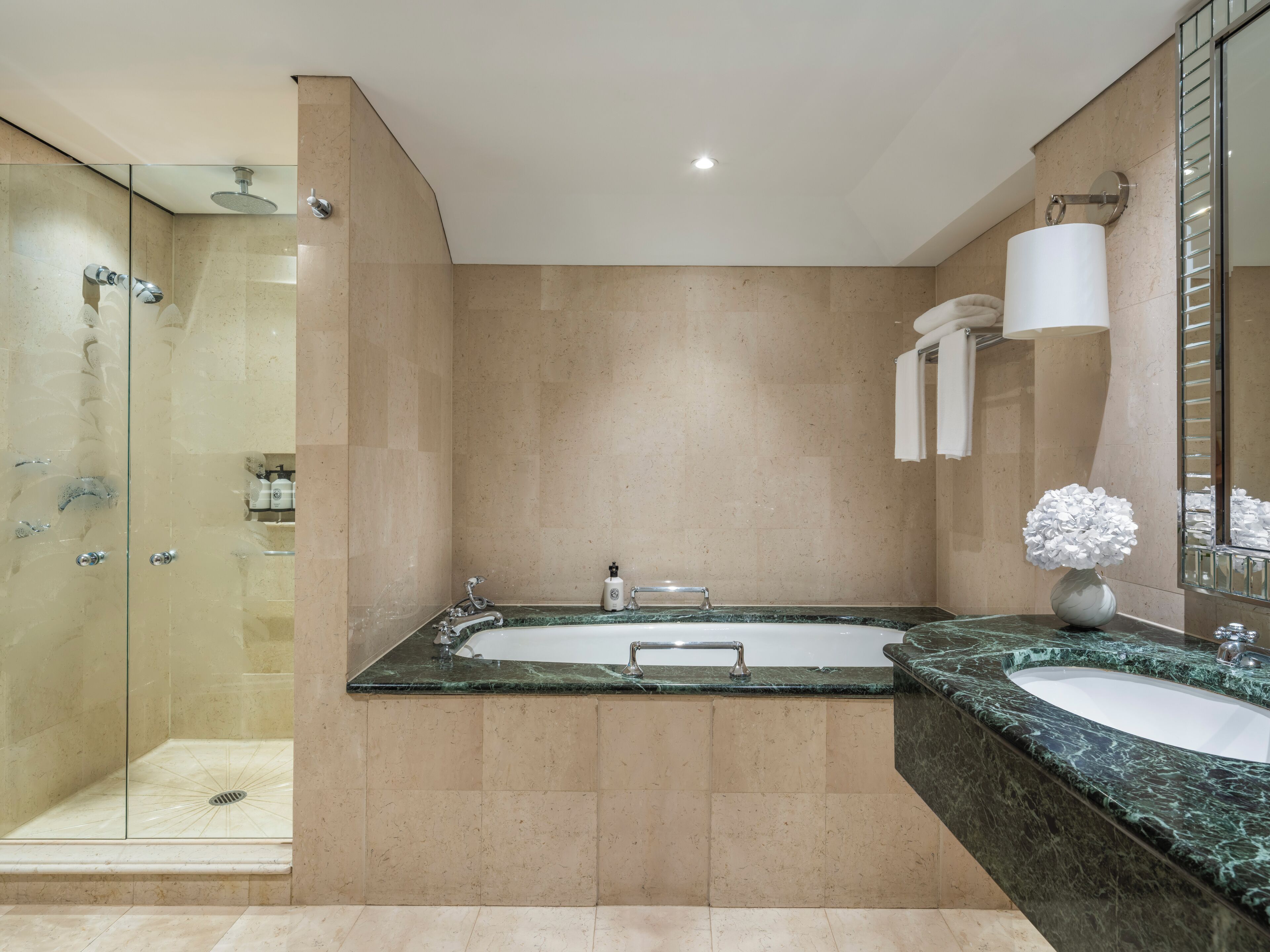 A modern bathroom with a glass-enclosed shower, a double sink vanity, and a large mirror.