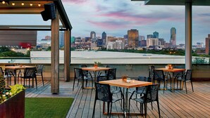 An outdoor dining area with tables and chairs, overlooking a city skyline. - Renaissance Dallas Hotel (Dallas)