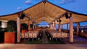 An outdoor venue with a covered seating area, a central aisle, and a backdrop of a city skyline. - Renaissance Dallas Hotel (Dallas)