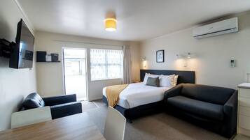 Une chambre d’hôtel moderne équipée d’un lit, d’un canapé, d’un bureau et d’une télévision.