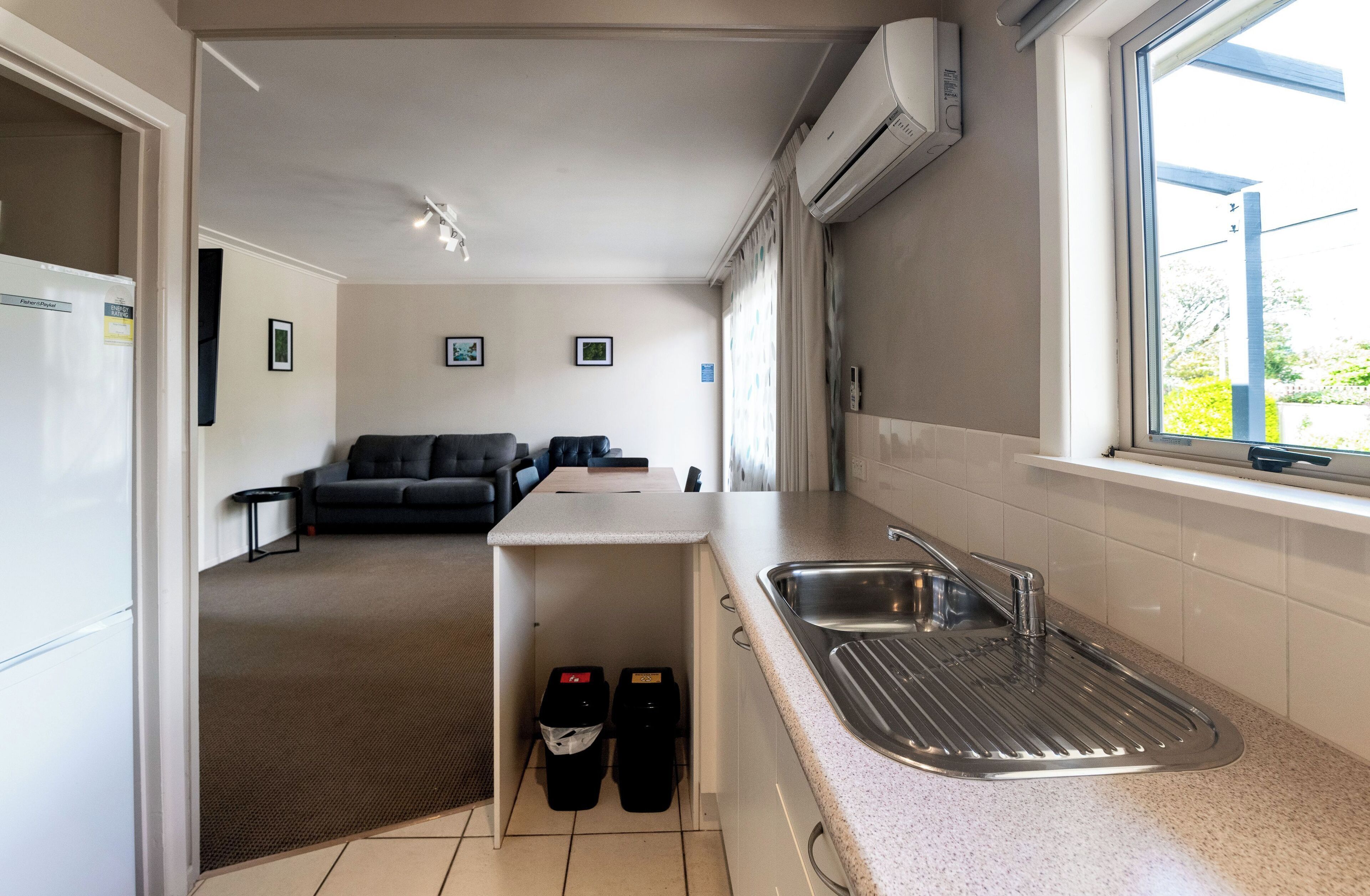 A compact kitchen with a built-in sink, a small island, and a window with a view.