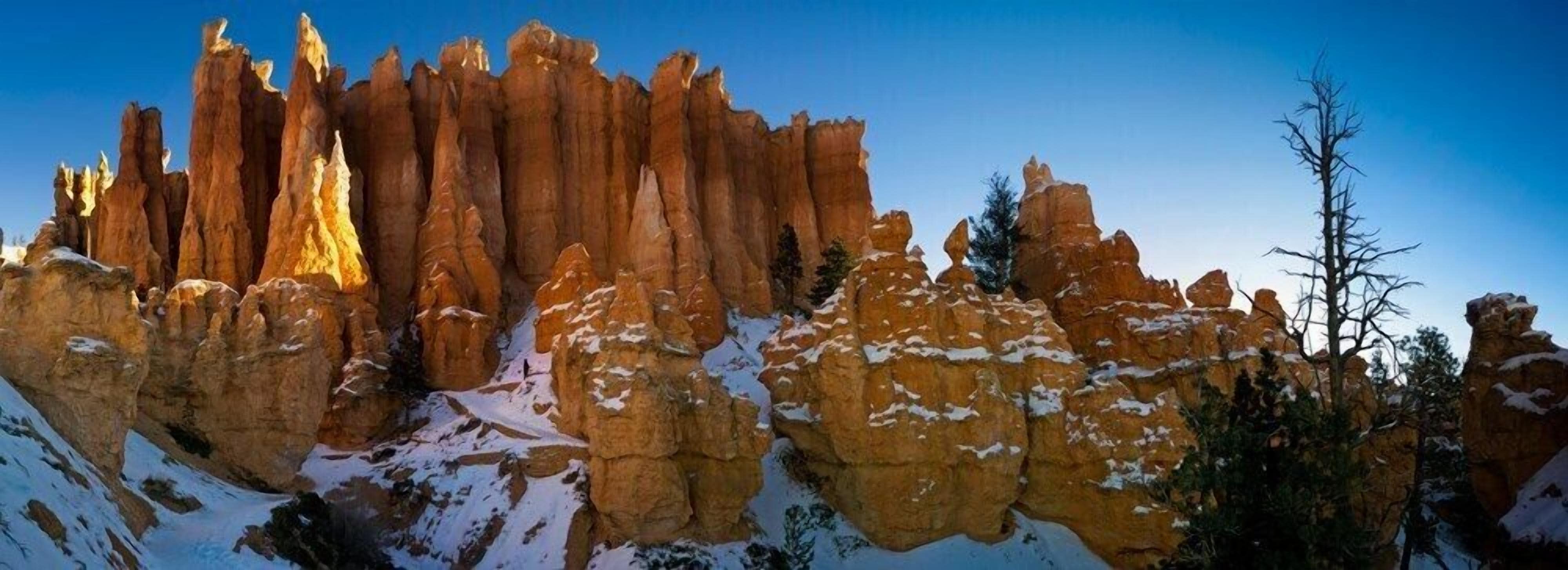 A panoramic view of a rugged landscape with towering rock formations and sparse vegetation, likely a natural park or protected area.