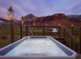 Un jacuzzi con vista a formaciones rocosas rojas.