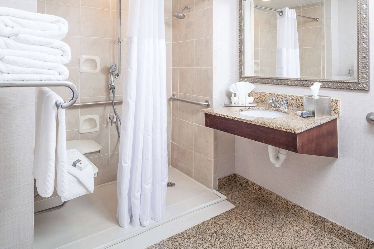 A modern bathroom with a shower, toilet, and sink.