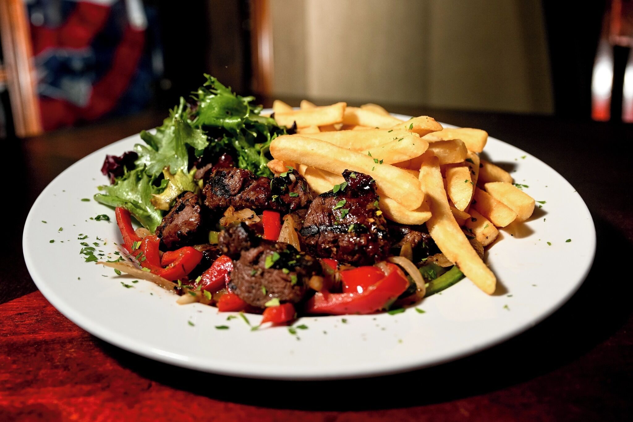 Une assiette contenant de la viande, des légumes et des frites.