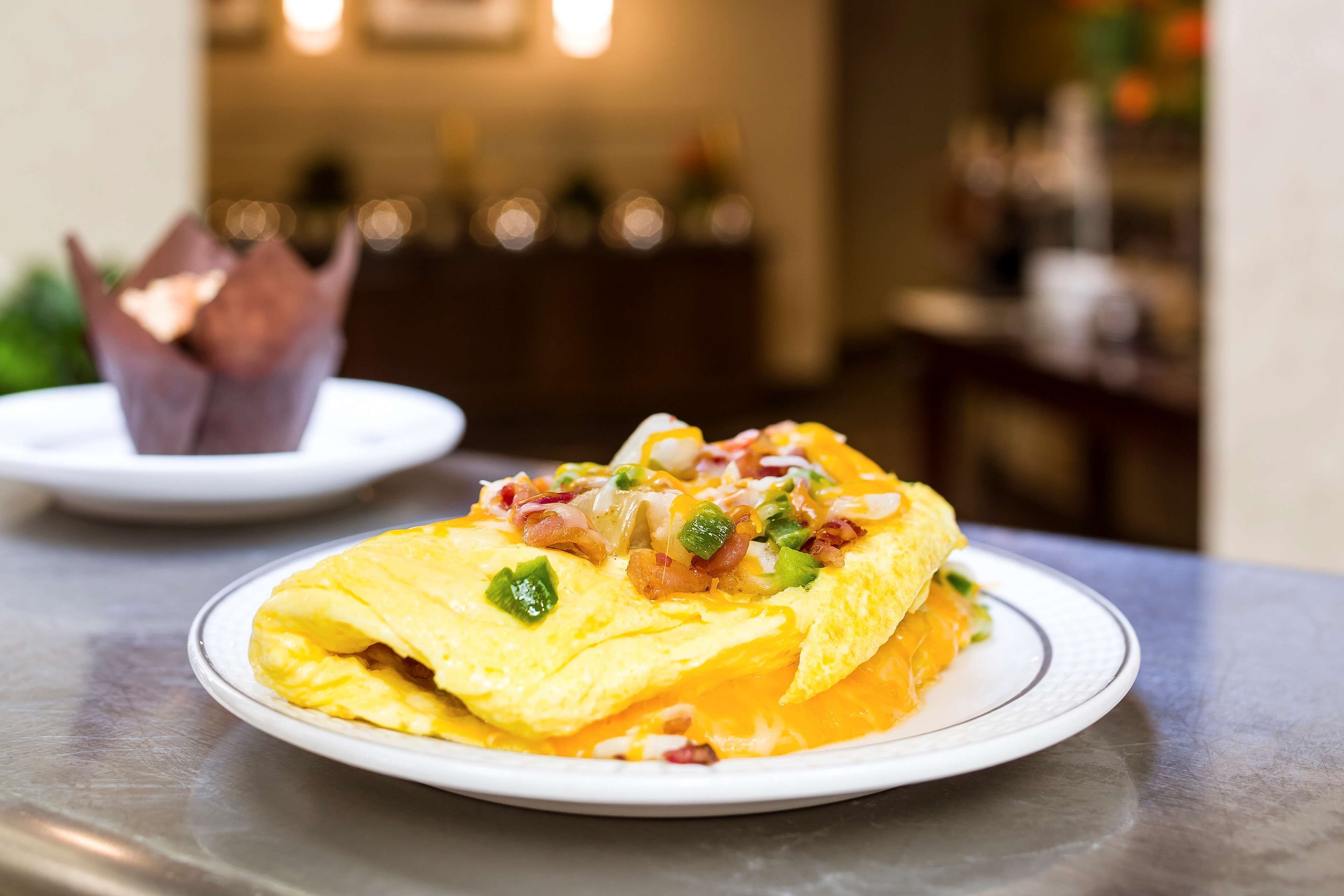A plate of food with an omelette and toppings.