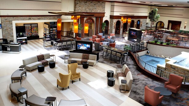 Eine geräumige Lobby mit Pool, mehreren Sitzbereichen und einer Bar.