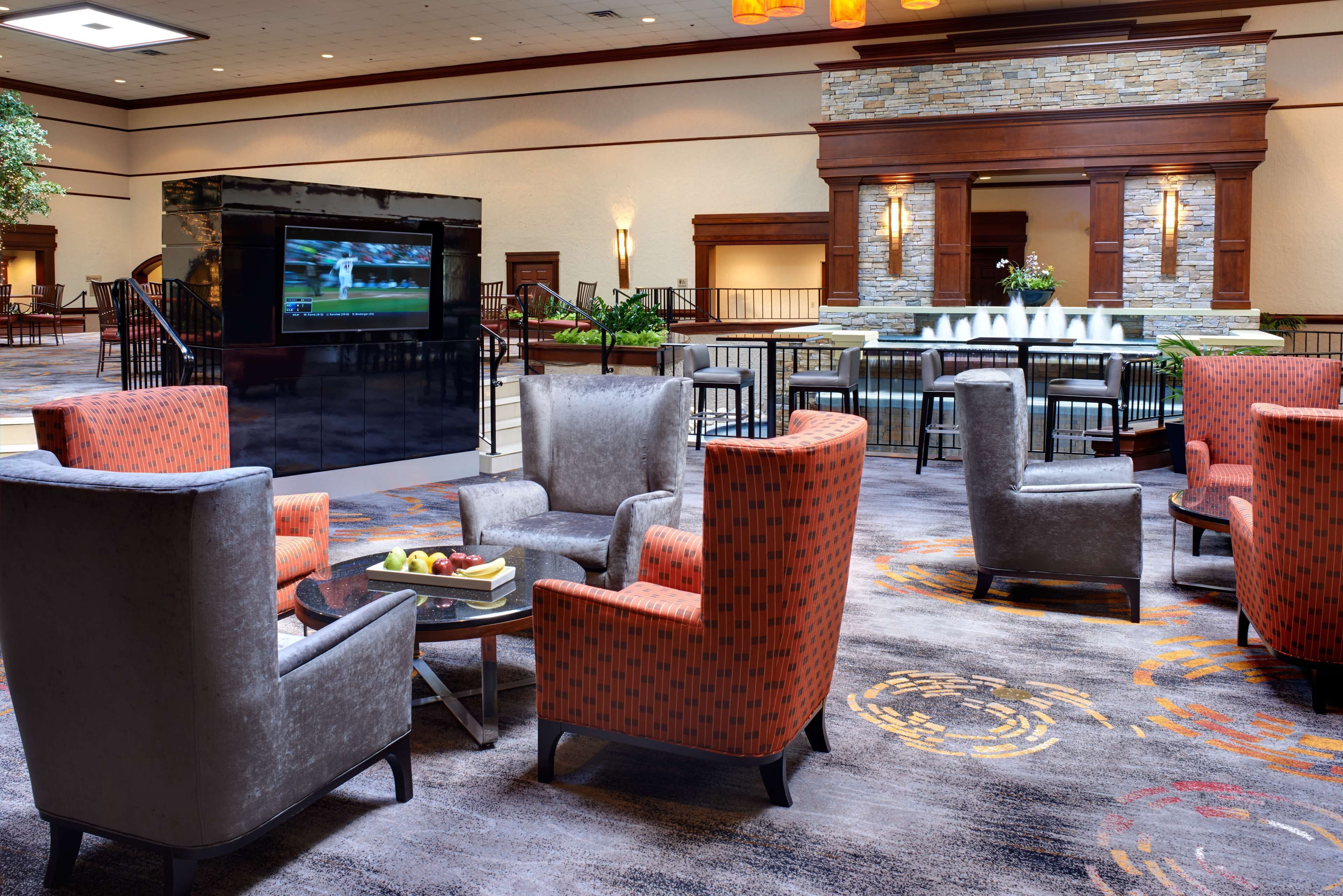A lobby with a TV, seating area, and a stone fireplace.