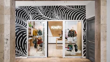 A clothing store with a zebra-striped wall design and glass doors.