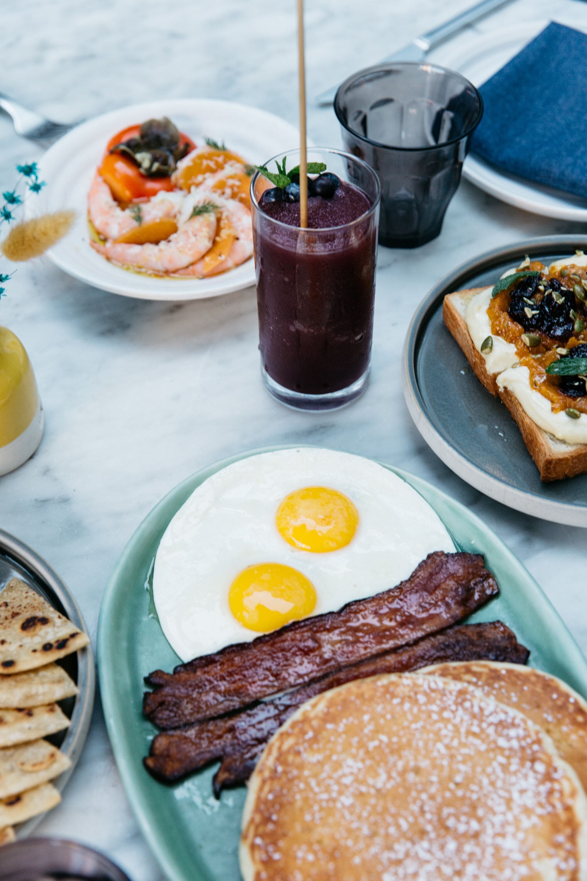 A breakfast plate with eggs, bacon, and pancakes.