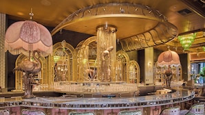 A bar with a circular layout, ornate chandeliers, and patterned bar stools. - Flamingo Las Vegas Hotel & Casino (Las Vegas)