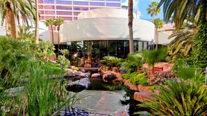 A hotel courtyard with a water feature, palm trees, and a modern building in the background. - Flamingo Las Vegas Hotel & Casino (Las Vegas)